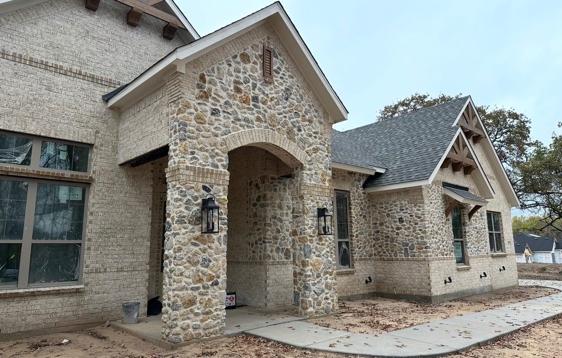 Angled view of the stone archway and brick walls of the new home