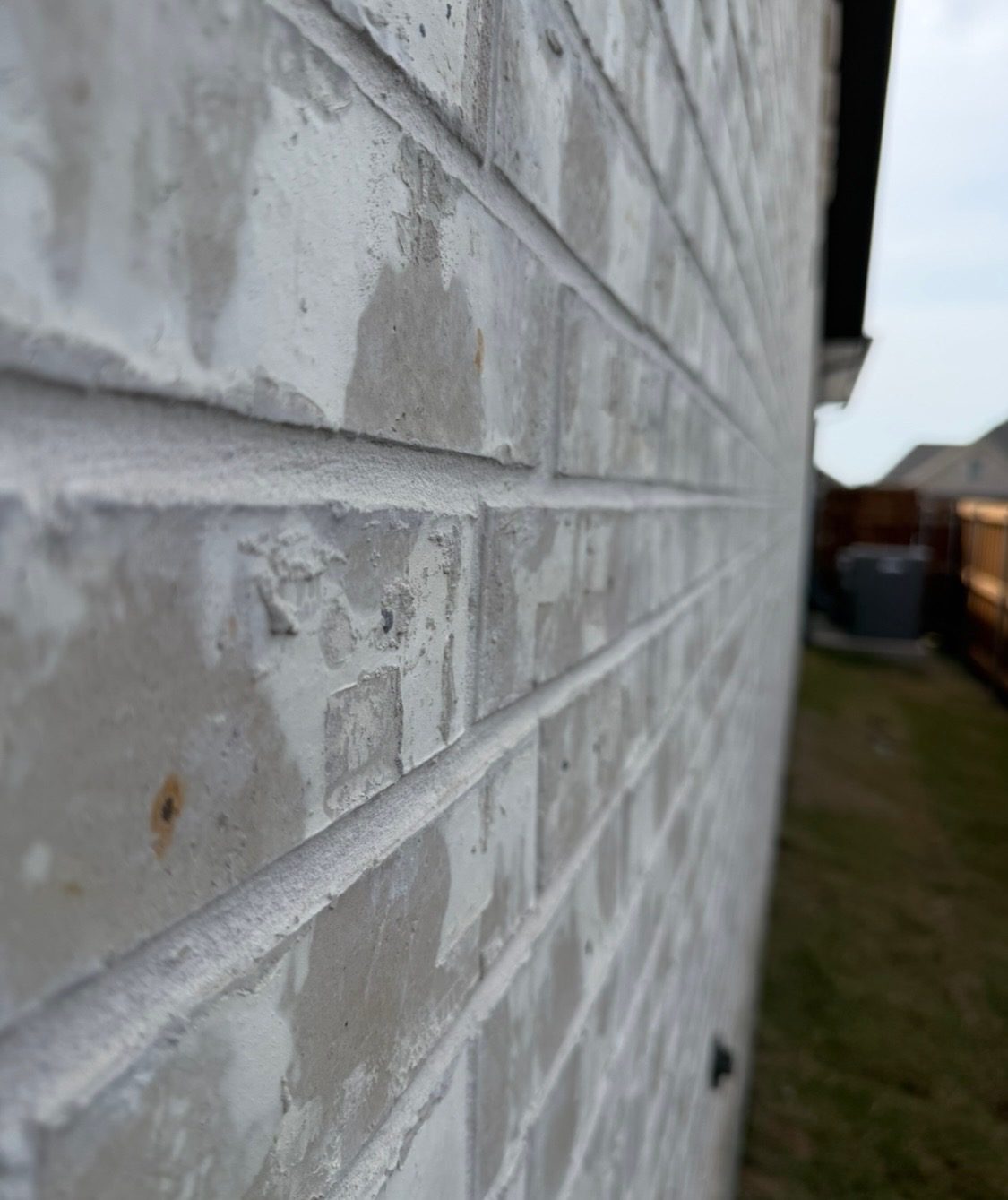 Light brick wall seen down its length, showing straight, level courses